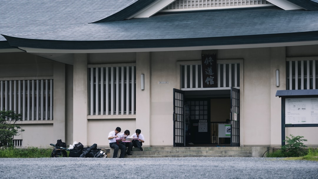 ：visitors reading manga on the lawn at the kyoto manga museum