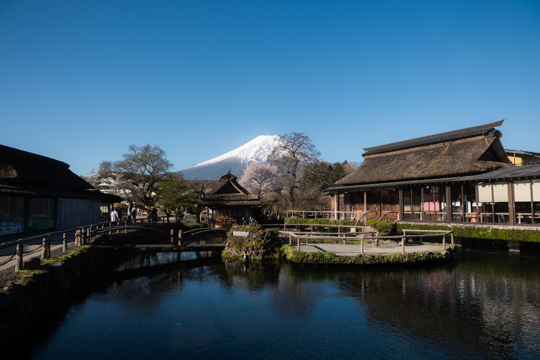 ：mount fuji behind thatched farmhouses at oshino hakkai