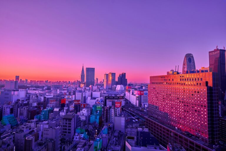 An aerial view of the Tokyo skyline under a vibrant purple and orange sky