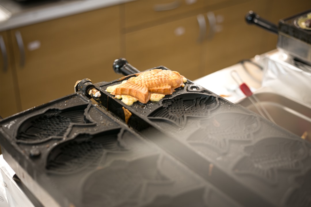 ：taiyaki fish shaped cakes cooking in cast iron moulds