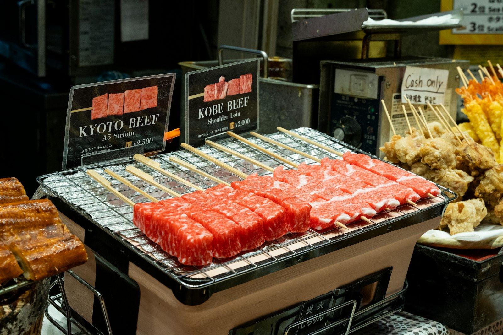 Raw kyoto and kobe beef skewers on a grill