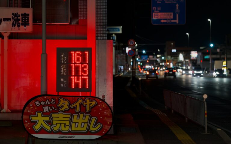 Neon signs glow on a wet street at night