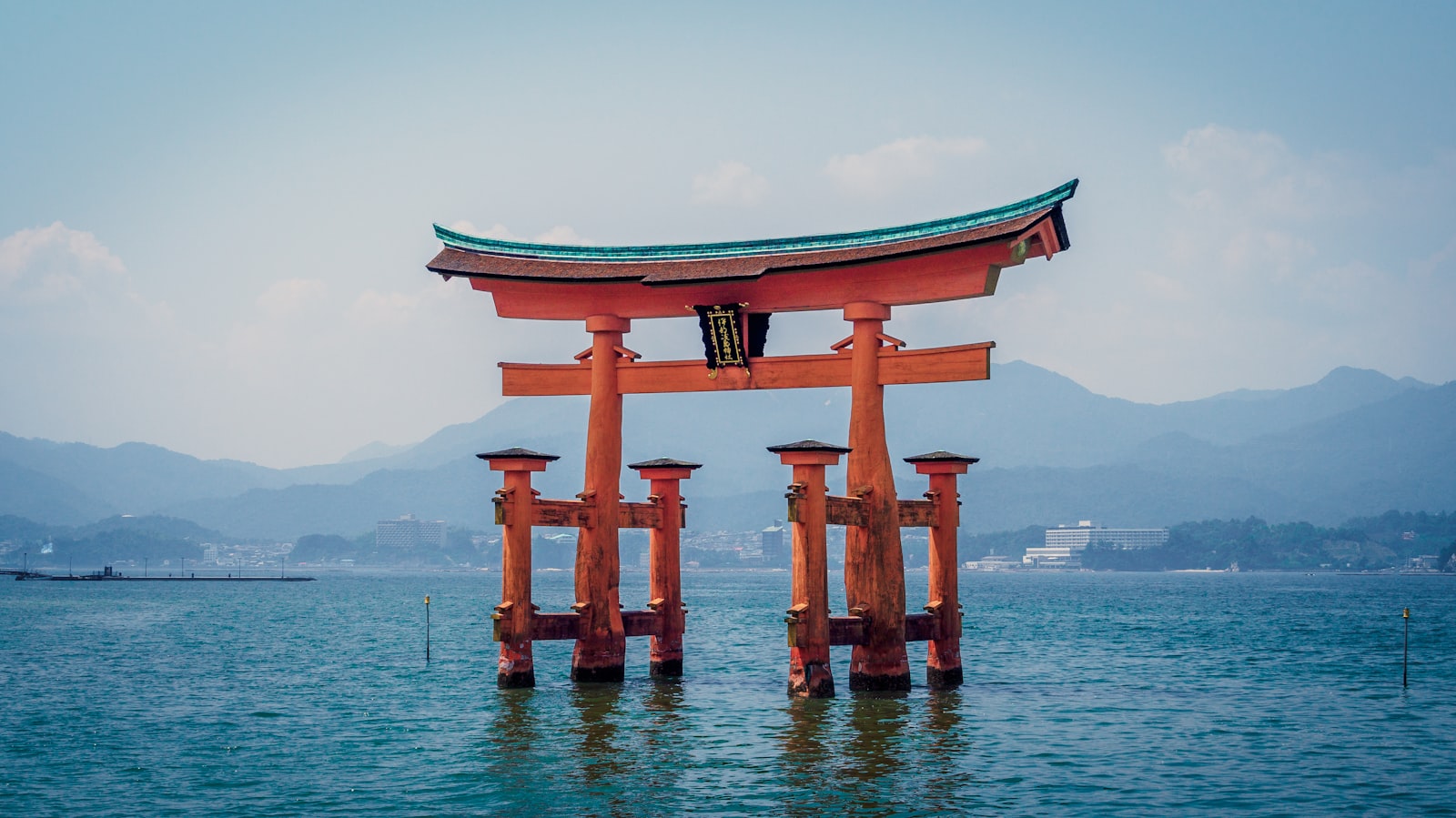The orange Itsukushima Shrine torii gate standing in the water at Hatsukaichi, Japan