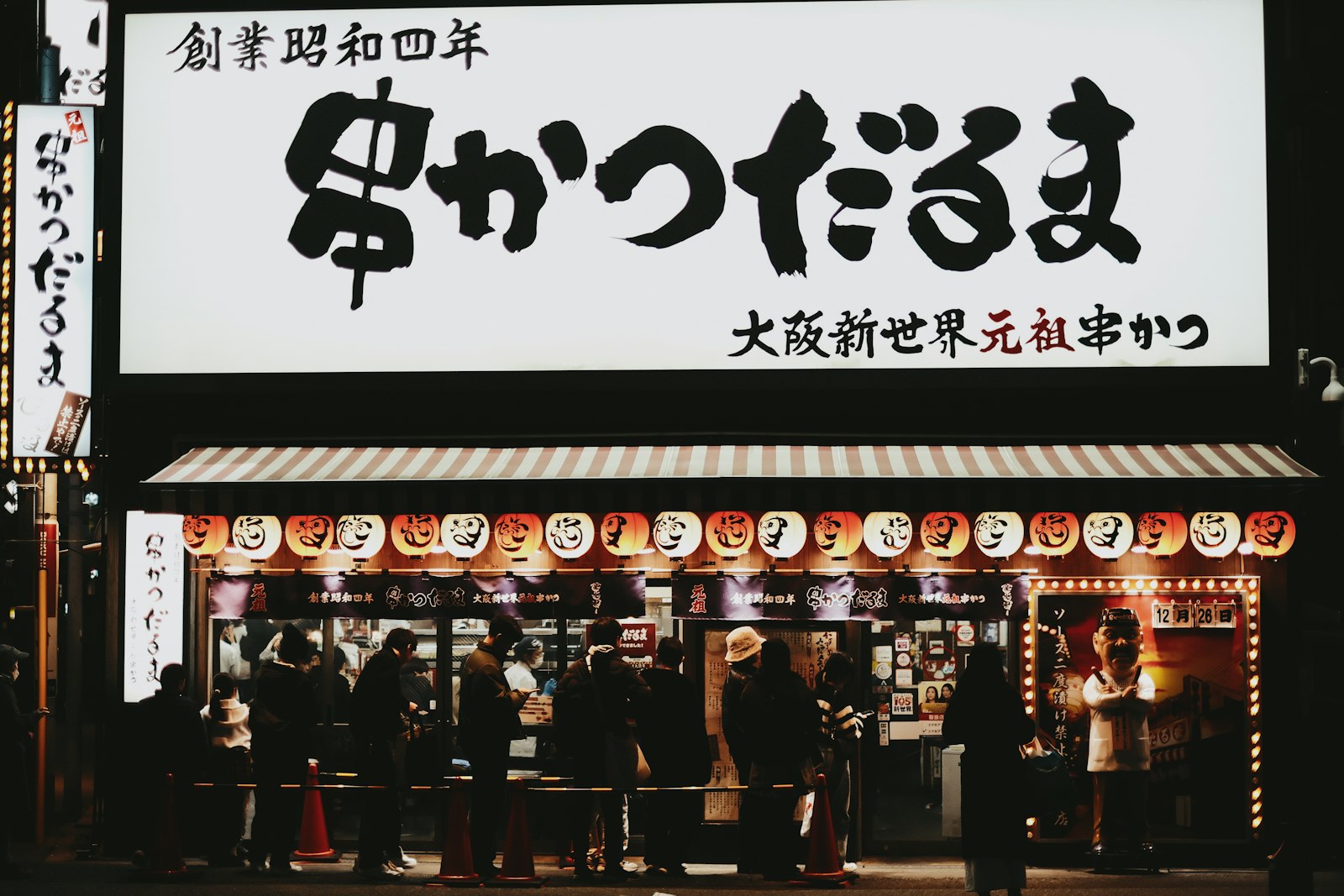 People queuing outside a japanese restaurant at night