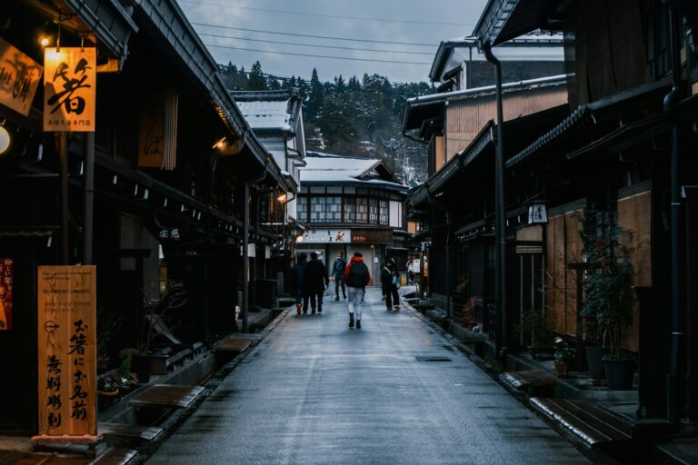 People walk down a snowy street in a historic town