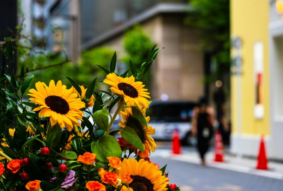 A bunch of sunflowers in a vase on the side of the road
