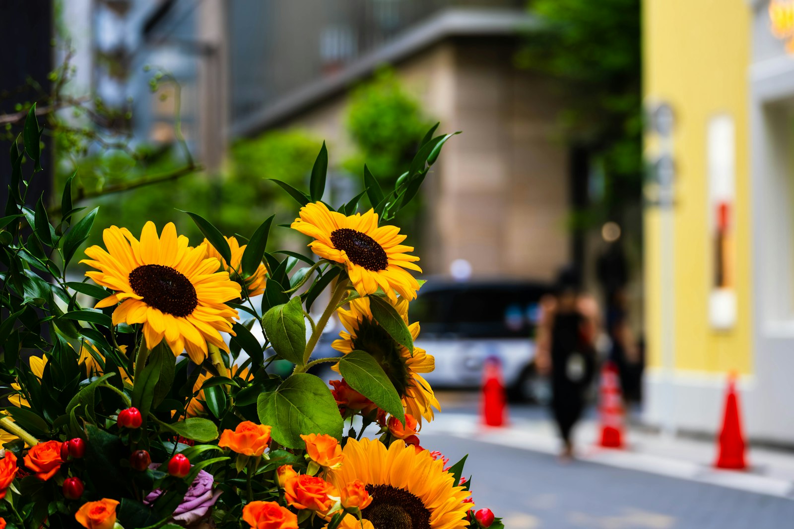 A bunch of sunflowers in a vase on the side of the road