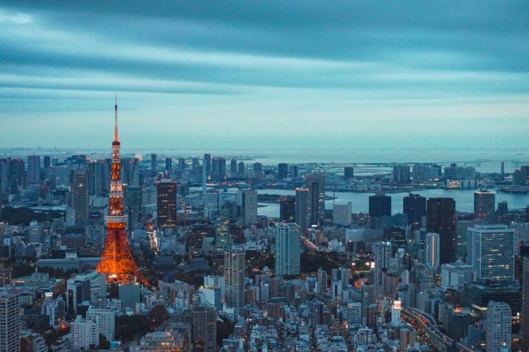 tokyo tower illuminated at dusk with city skyline