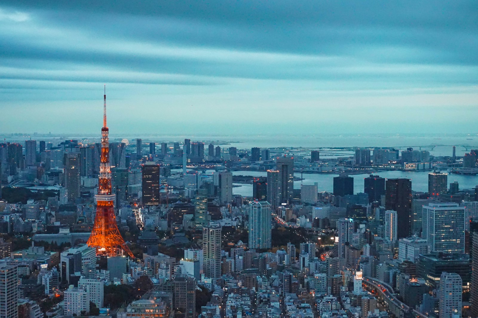 tokyo tower illuminated at dusk with city skyline