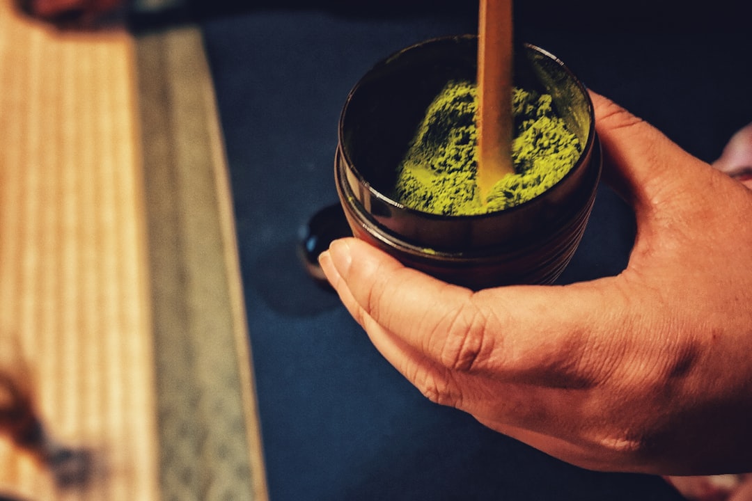 :bowl of whisked matcha with a bamboo chasen in kyoto