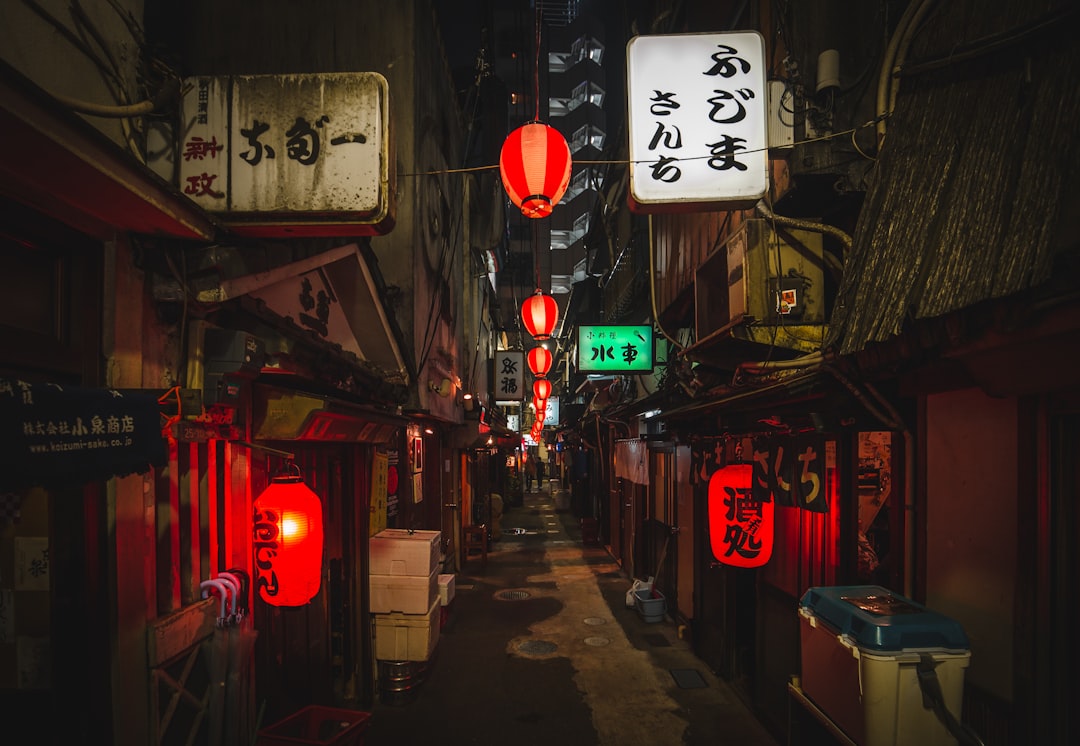 :red lanterns over the narrow lane of nonbei yokocho in shibuya at night