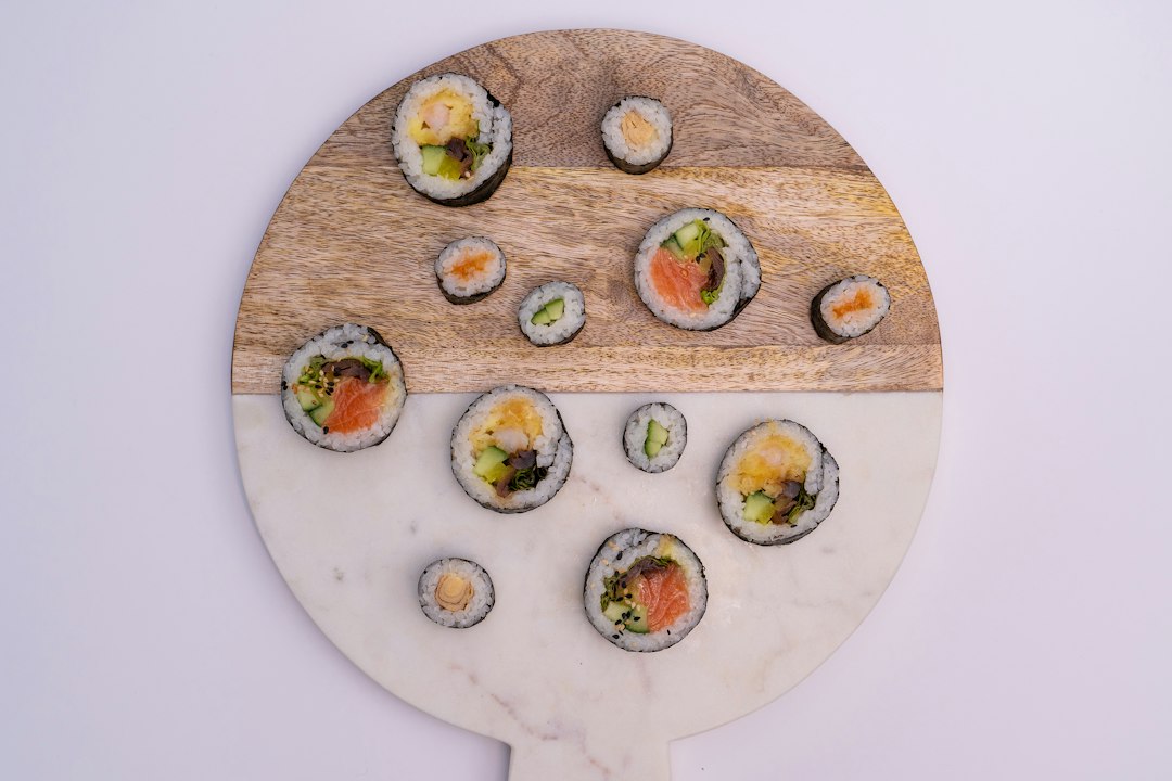 ：different sushi rolls including hosomaki and futomaki on a wooden board