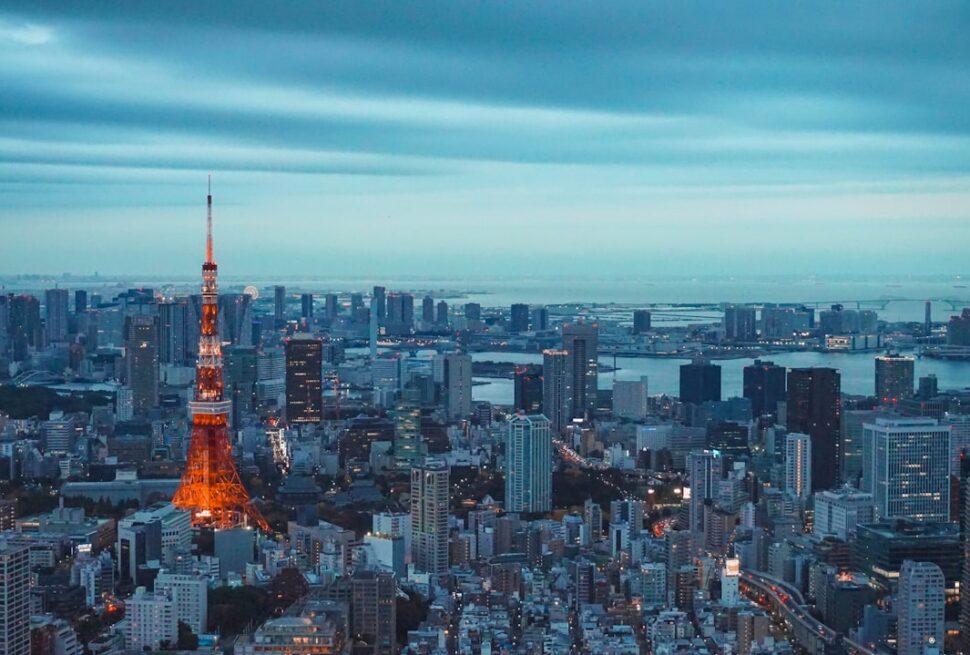 ：tokyo tower lit orange at dusk above minato