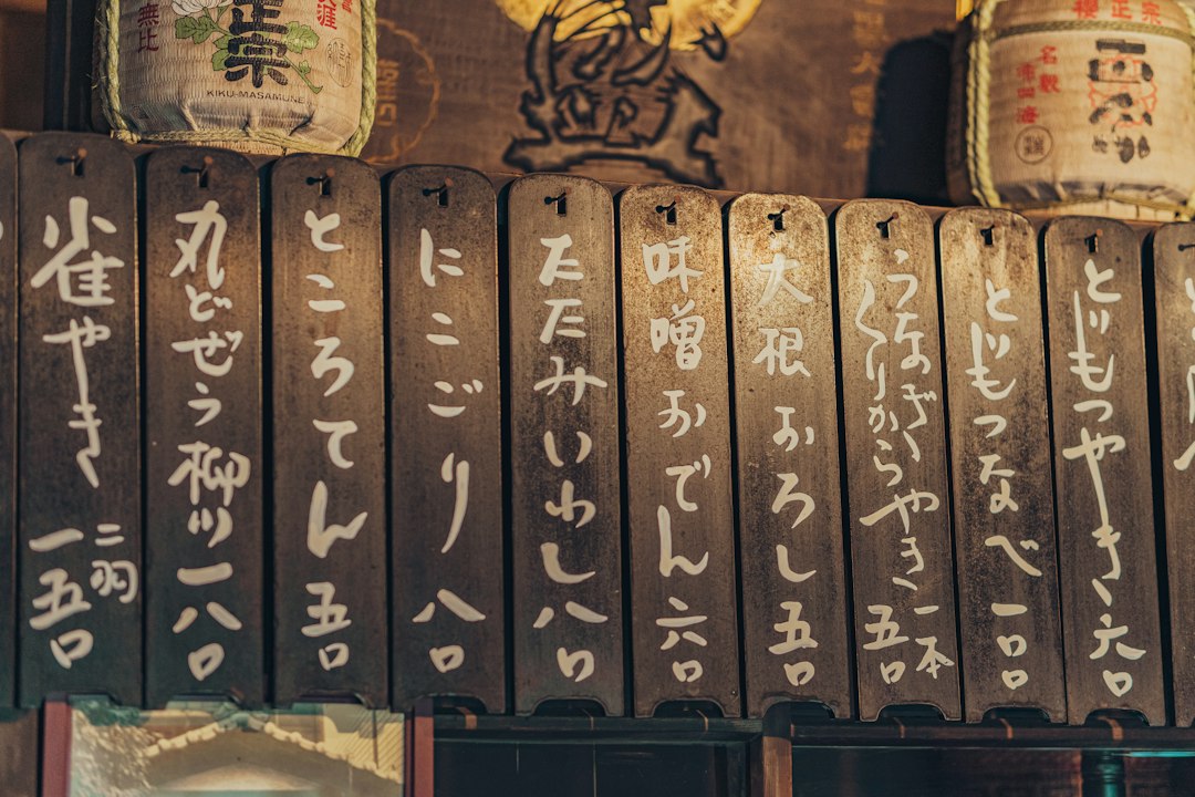 :handwritten wall menu inside a small izakaya in japan